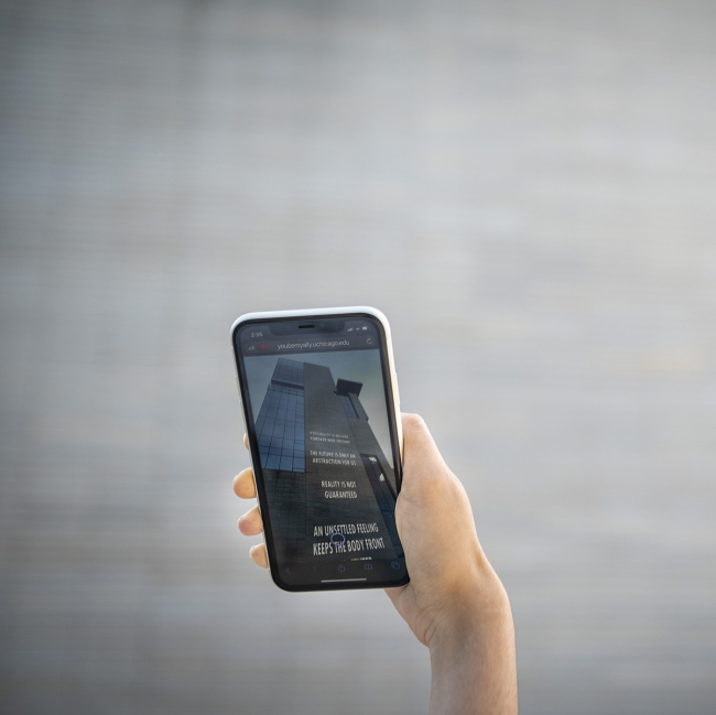 Hand holding a phone to a building with text on the phone