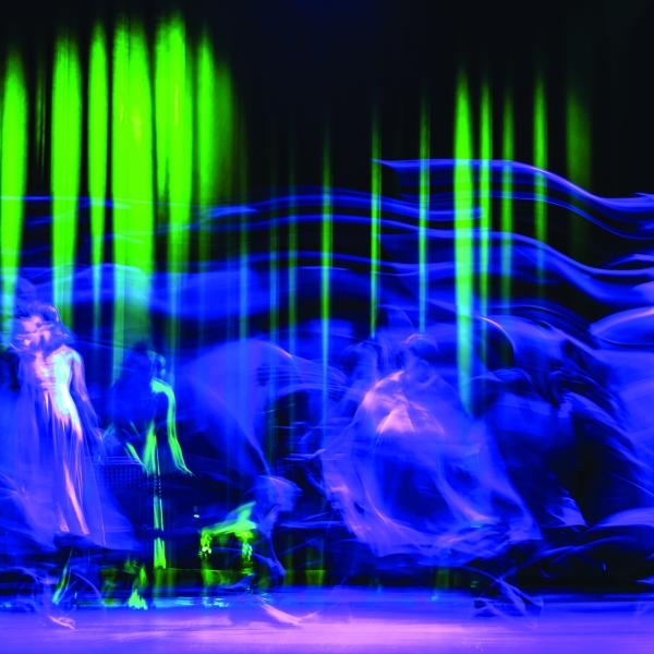 Abstract purple, green, and black image of people dancing
