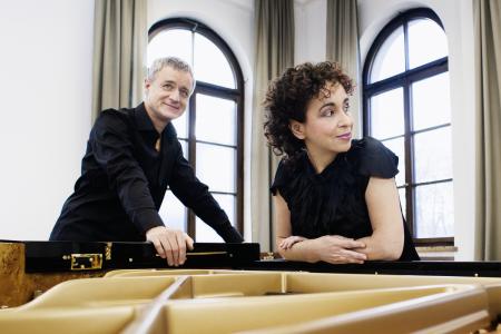 Piano duo Yaara Tal and Andreas Groethuysen lean over a piano