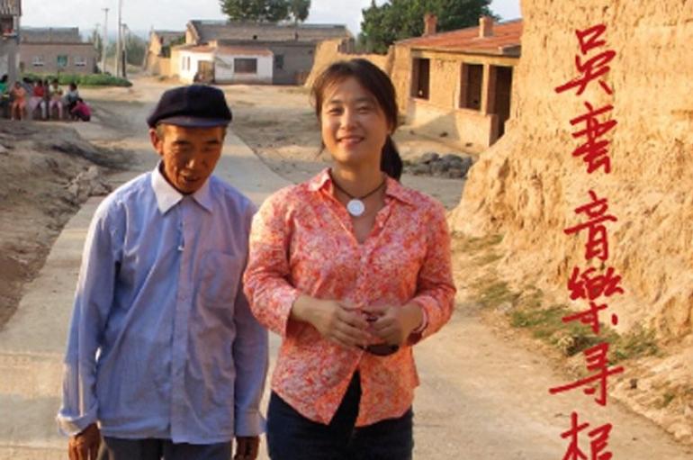 Cover of Discovering a Musical Heartland: Wu Man's Return to China featuring Wu Man walking with an older Chinese man down a dirt road