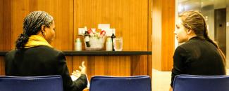 A student and a visiting writer chat at an event.