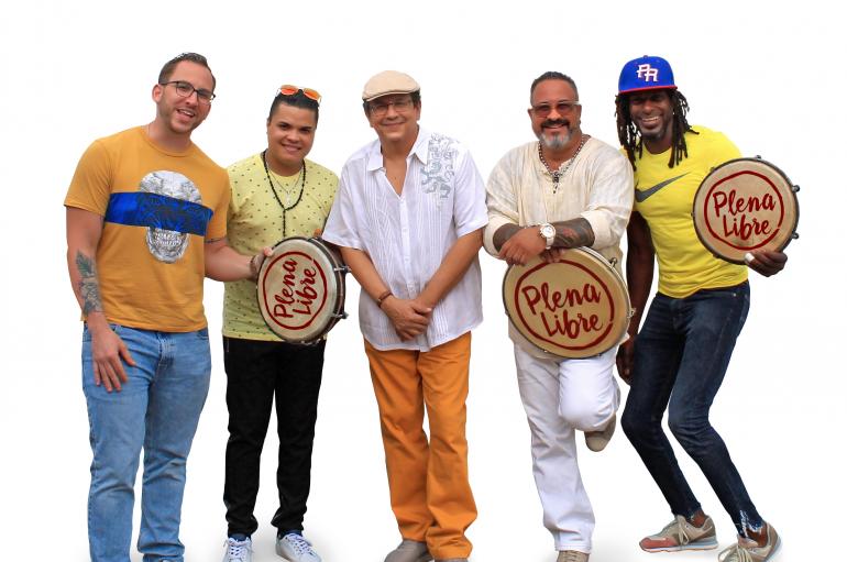 The members of Plena Libre wearing colorful clothing