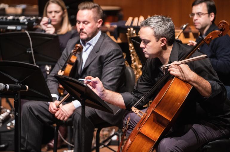 Doyle Armbrust and Russel Rolen lean over their stands in a rehearsal of the Grossman Ensemble