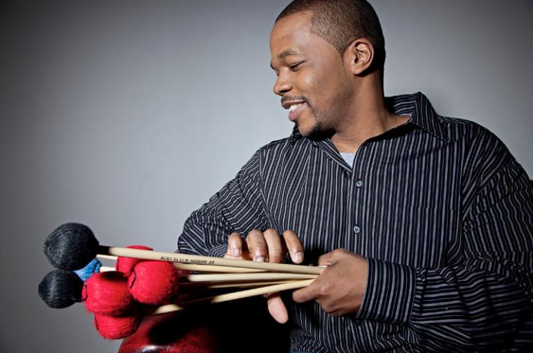 Warren Wolf holding a bundle of vibraphone mallets