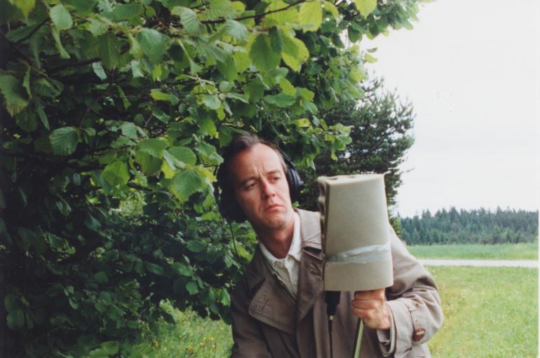 Peter Aberlinger holding a large microphone in a field