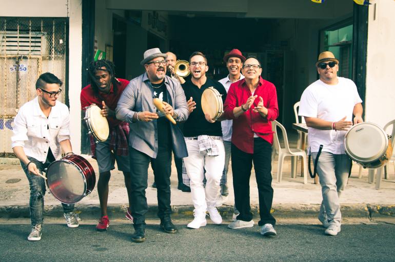 Plena Libre playing drums and horns, singing, and dancing