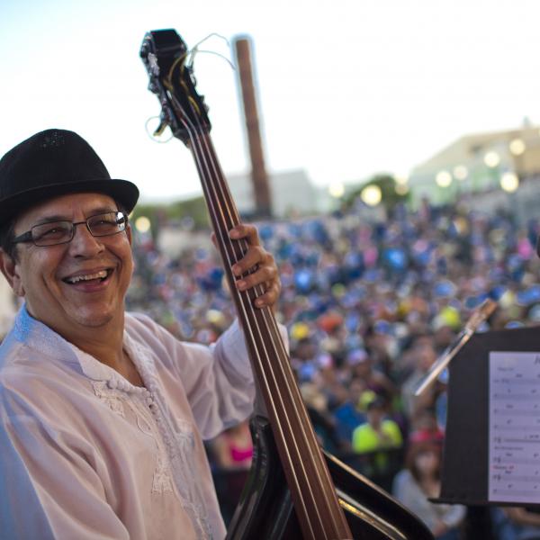 Gary Nunez on stage with an audience behind him