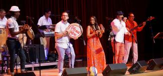 Plena Libre singing and dancing on stage with drums and hand percussion