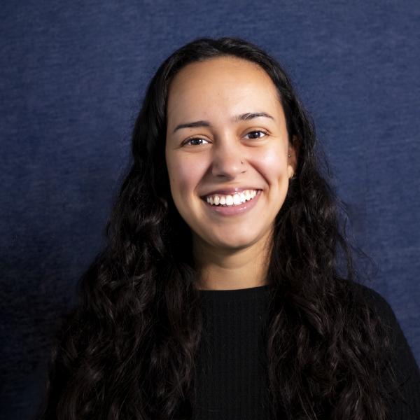 Young woman with long dark hair looking at the camera and smiling